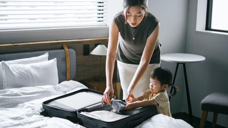 Woman and child packing suitcase