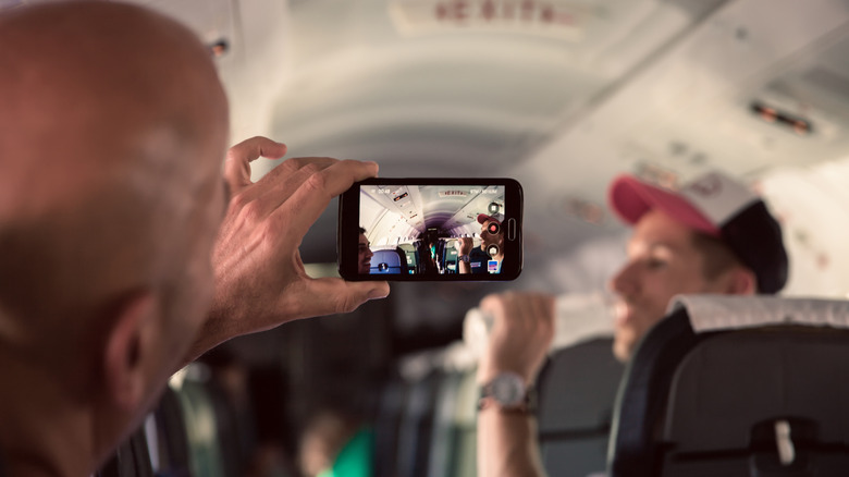 Man uses camera on plane