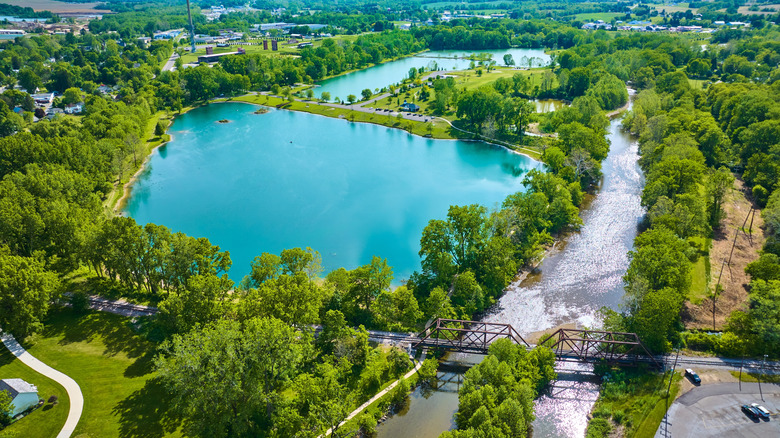 An aerial view of the blue pond and lush trees in Ariel-Foundation Park in Mount Vernon, OH beside the Kokosing River