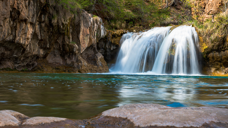 waterfall flowing into turquoise pool