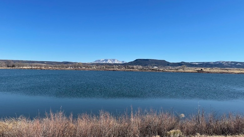 Becker Lake with snow-capped mountain in background with clear blue sky