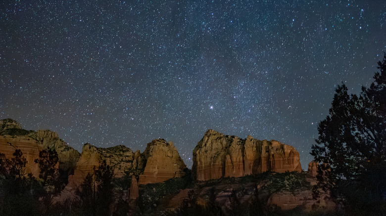 Starry night sky with red rock monuments in Arizona