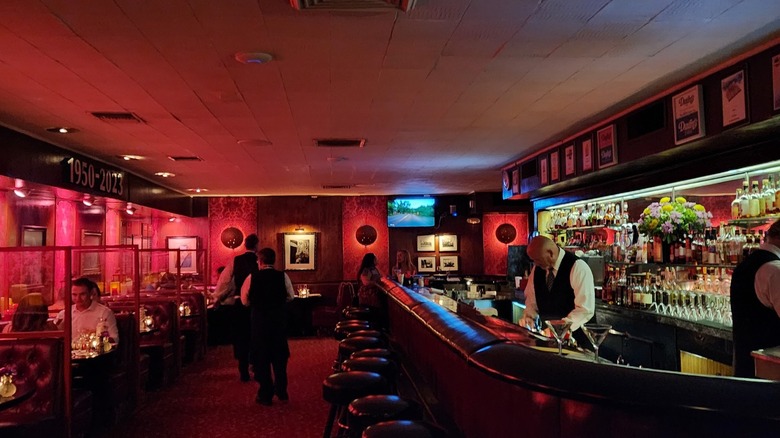 Red, dimly lit interior of Durant's restaurant in Phoenix with booths and a bar