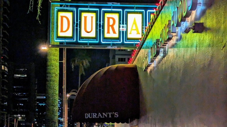 Durant's Steakhouse signs and entrance with palm tree at night