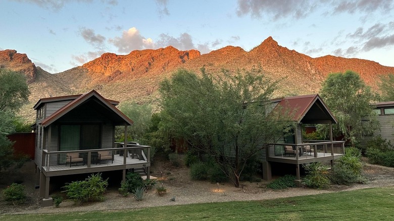 A view of cabins at Castle Hot Springs in Arizona with red rock formations in the background