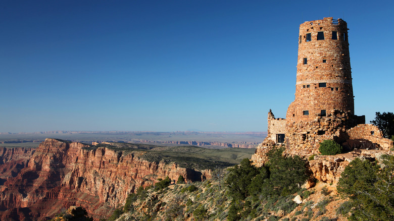 Weathered, sandstone watchtower stands on edge of Grand Canyon.