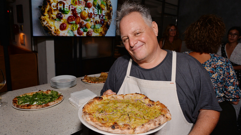 Chris Bianco holds rosa pizza with Chef's Table sign behind him