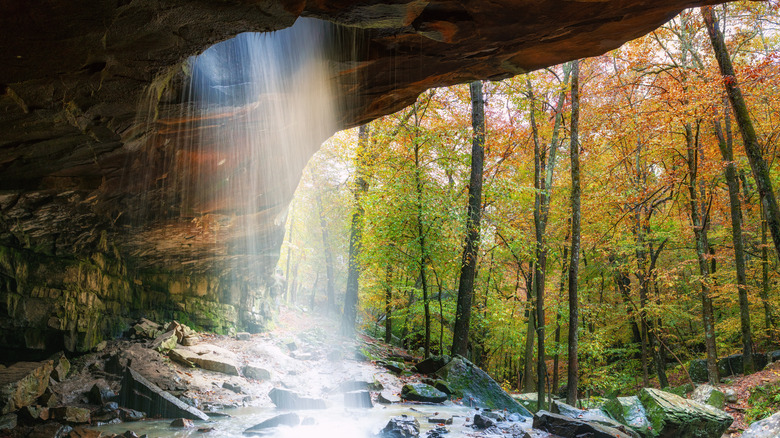 A waterfall flowing through a hole in a cave roof