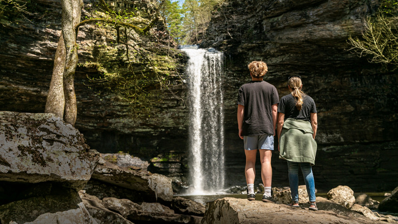 Two hikers admiring a waterfall in Arkansas