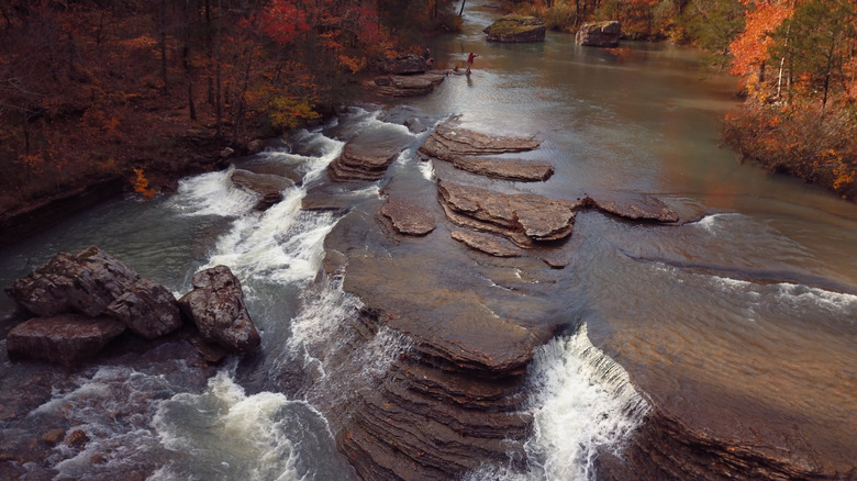 A river waterfall in Arkansas surrounded by fall foliage