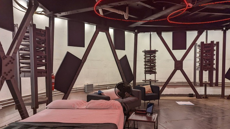 Bed and chairs with futuristic metal decoration in round room Titan Ranch