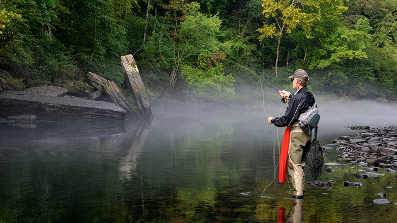 Middle-aged man fishing on a misty Arkansas lake