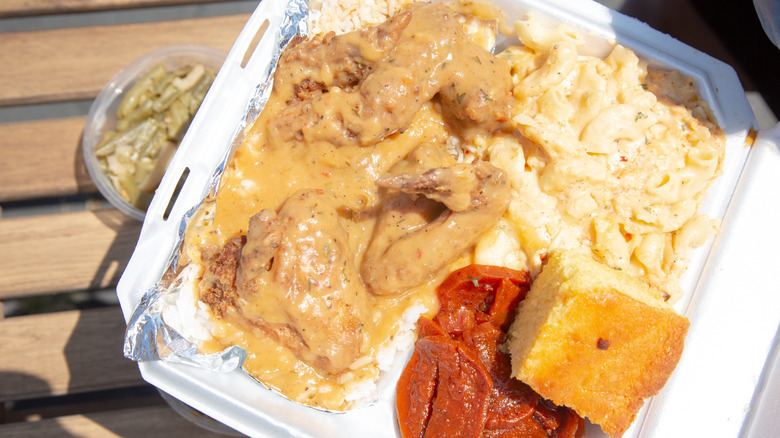 A styrofoam container packed with soul food