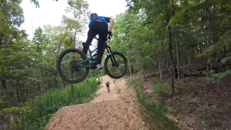 Mountain bike going over ramp, with another ahead of him, at OZ Trails Bike Park, Arkansas