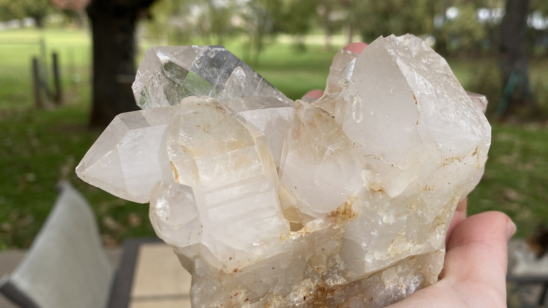 A hand holds a chunk of quartz crystal at an old mine in Arkansas.