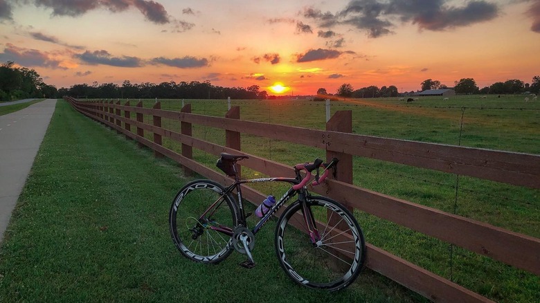 Bike next to fence on Razorback Regional Greenway at sunset