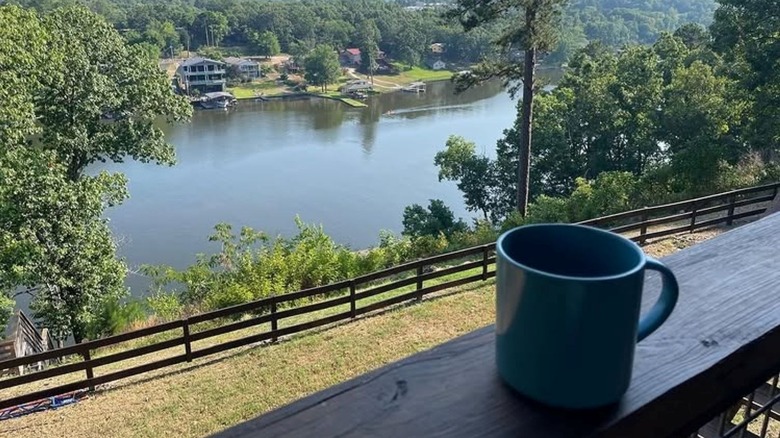 A coffee cup on a balcony overlooking the water