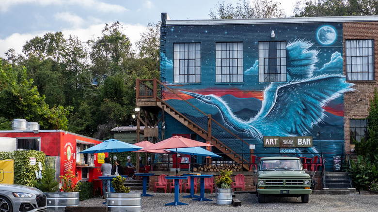 A blue art mural of a bird painted on a building in Asheville, North Carolina's River Arts District
