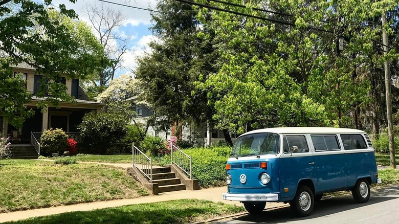 Lush greenery surrounding a house and street where an old VW is parked in Historic Montford area of Asheville, North Carolina