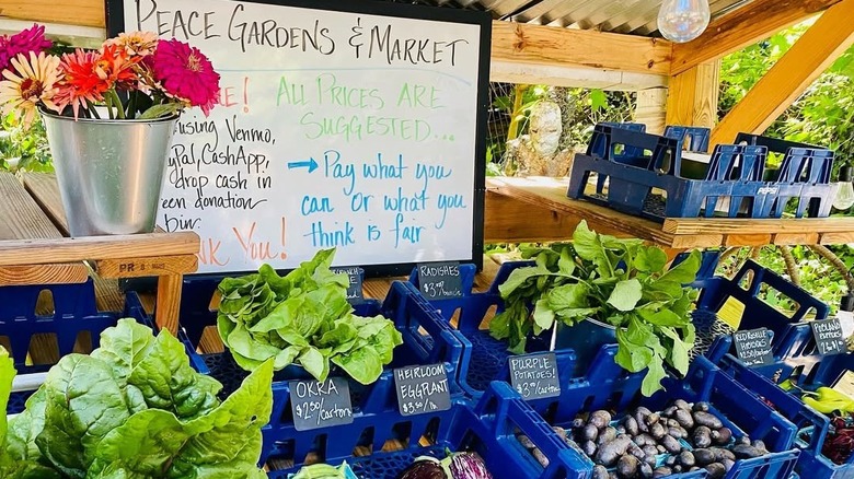 Peace Gardens and Market farmstand with a sign and produce baskets