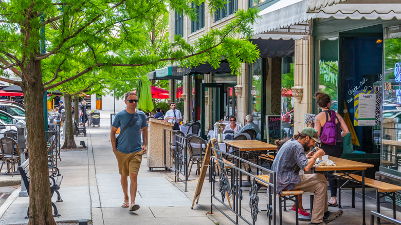 Man walking down a street in Asheville, North Carolina, lined with restaurants.