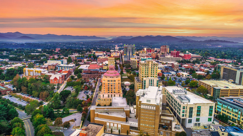 Dusk over Downtown Asheville cityscape with North Carolina mountains in the background