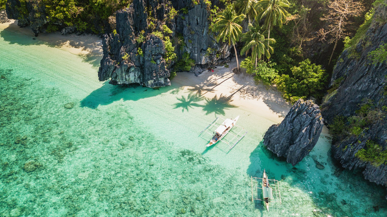 Beautiful Entalula Island Beach Lagoon with typical filipino Balangay Boats.