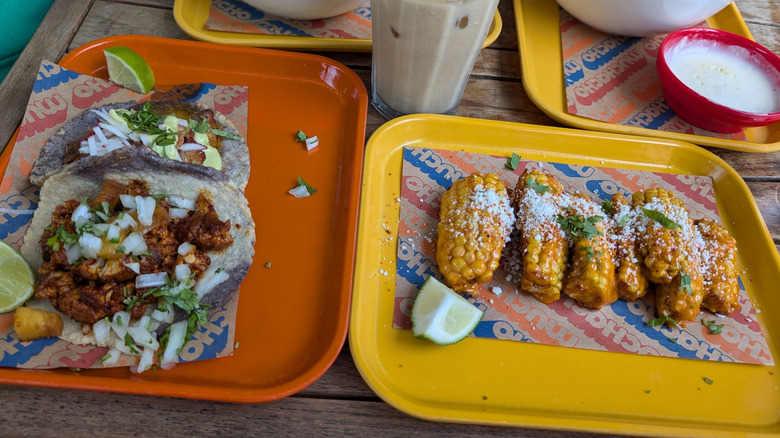 Corn ribs and house-made tacos on trays at Muchacho