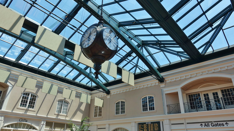 Glass ceiling with big clock and sign to gates Savannah/Hilton Head International Airport
