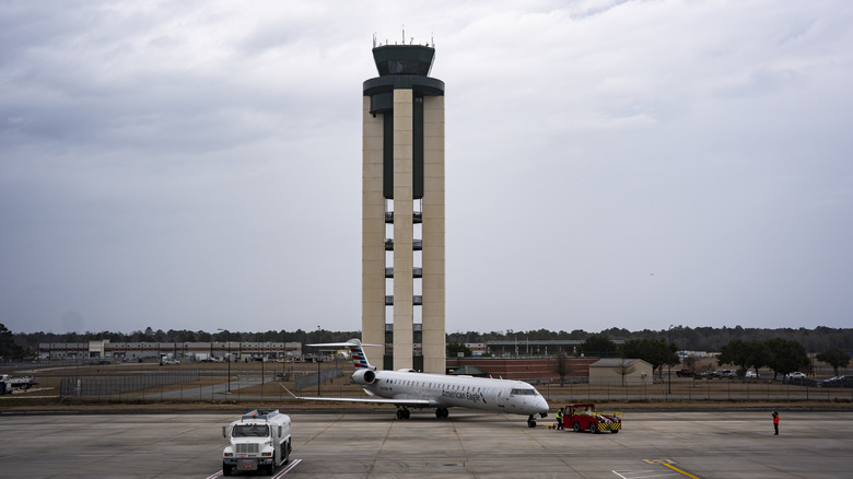Tall control tower with American Eagle airplane in front cloudy day Savannah/Hilton Head International Airport