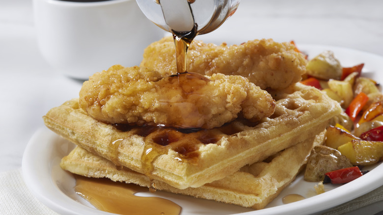 Fried chicken and waffles on a plate with syrup