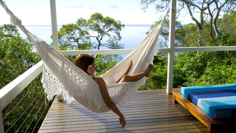 A woman resting in the hammock on the deck of a Lizard Island Resort room