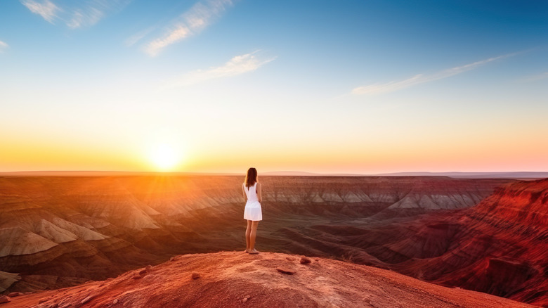 Woman in white dress watching the sunset over Karijini National Park in Western Australia