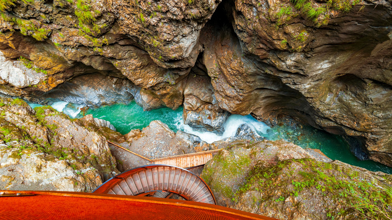 Turquoise water in an Austria gorge near a brown helix bridge