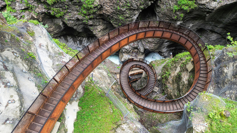 A spiral, metal staircase descends into a rocky gorge, Austria