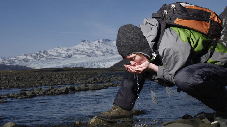 Hiker drinking water from a glacier in Iceland