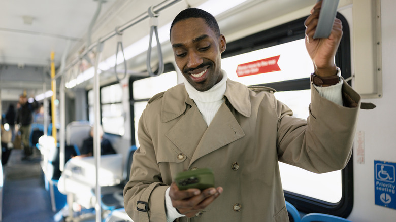 A man on a bus holding a cell phone
