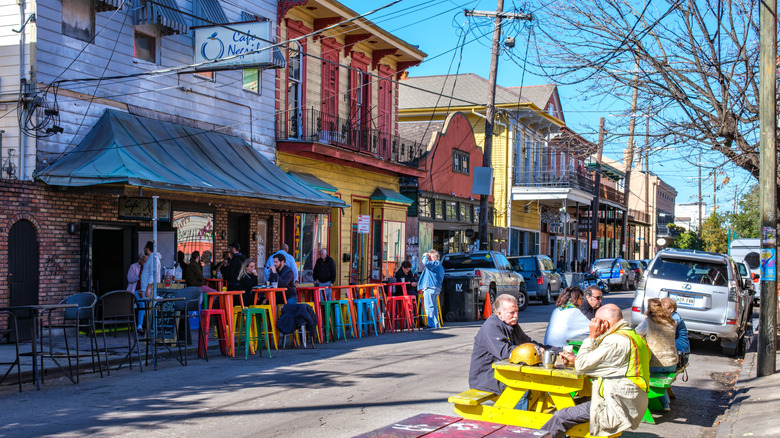 Patrons eating outside at a daytime scene along Frenchmen Street