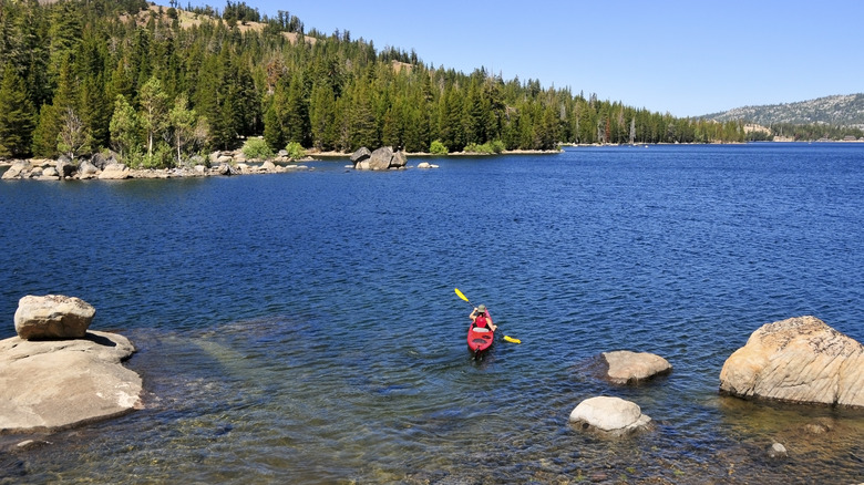 a kayaker paddles across Caples Lake