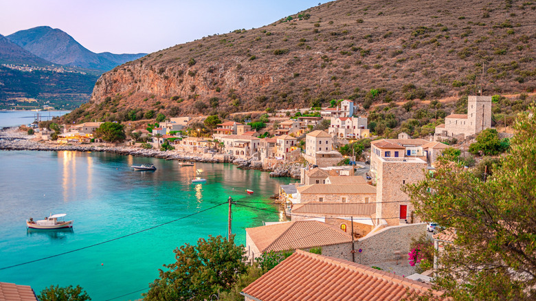 view of limeni harbor and stone houses at dusk
