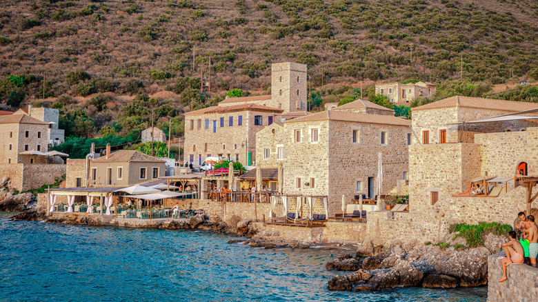 people enjoying the views and sun at limeni village in greece