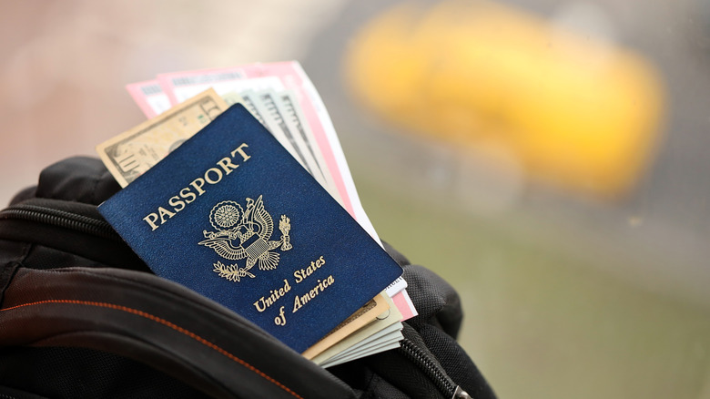 United States passport and money positioned on a bag