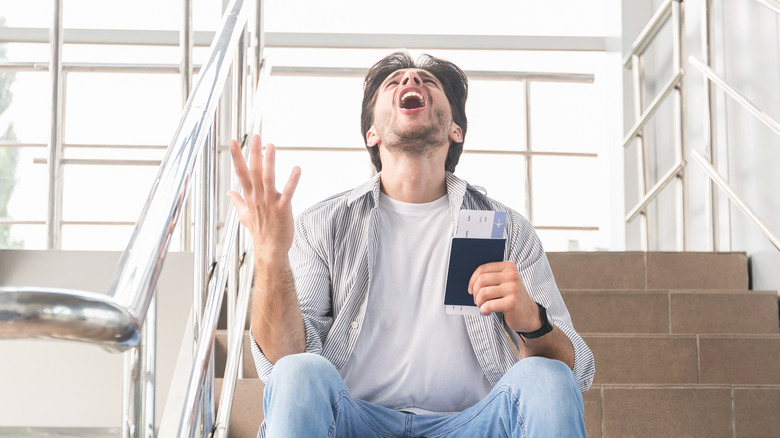 Man holding passport and yelling