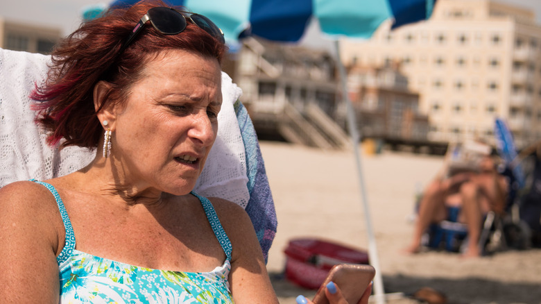 Angry boomer on her cellphone at the beach
