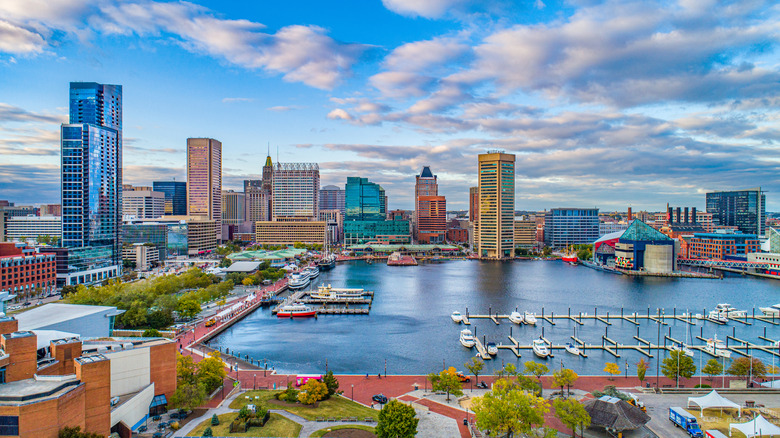 Drone shot of the Inner Harbor promenade with shops, restaurants, and boats on the water in Baltimore, Maryland