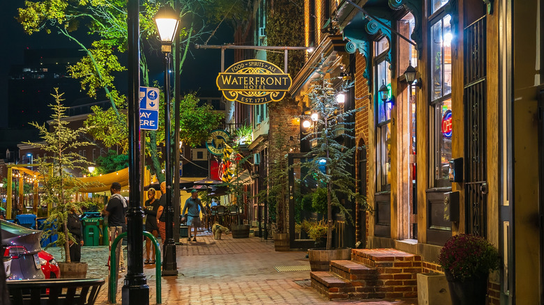 Thames Street in Fell's Point at night, with the Waterfront Hotel sign in the foreground