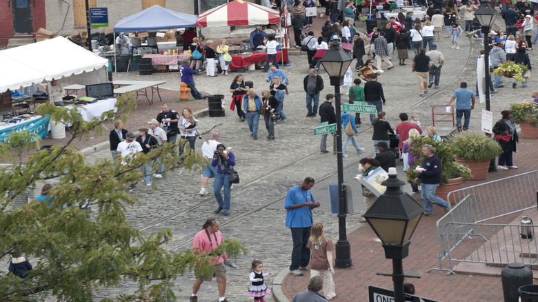 Aerial view of the Fell's Point Fun Festival, with crowds perusing rows of tents along a building-lined street