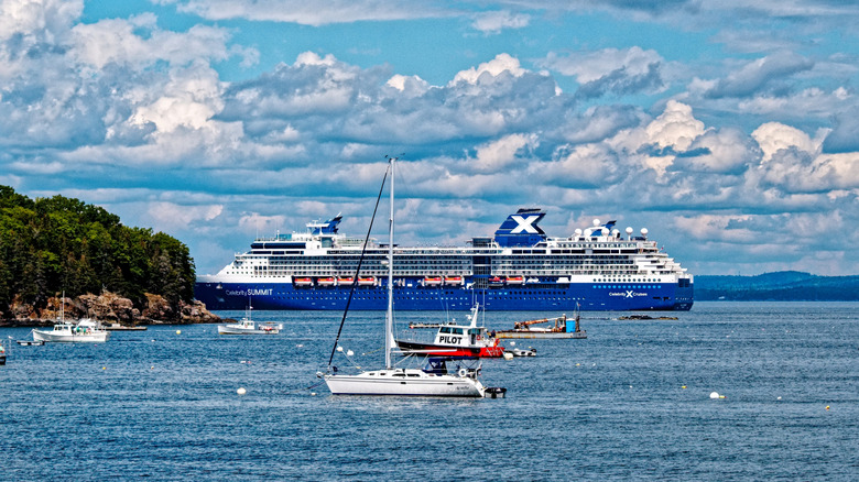 Cruise ship and sailboats anchored off coast of Bar Harbor, Maine on partly cloudy day