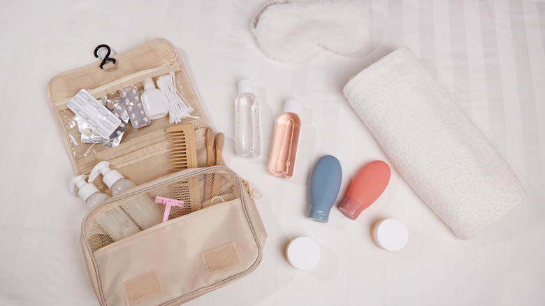 Toiletries and travel essentials spread out on white surface