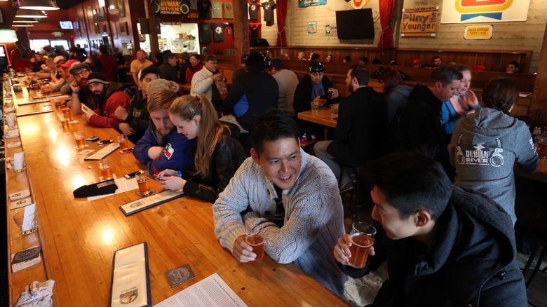 Craft beer fans sipping rare triple IPA Pliny the Younger at Russian River Brewing Company.